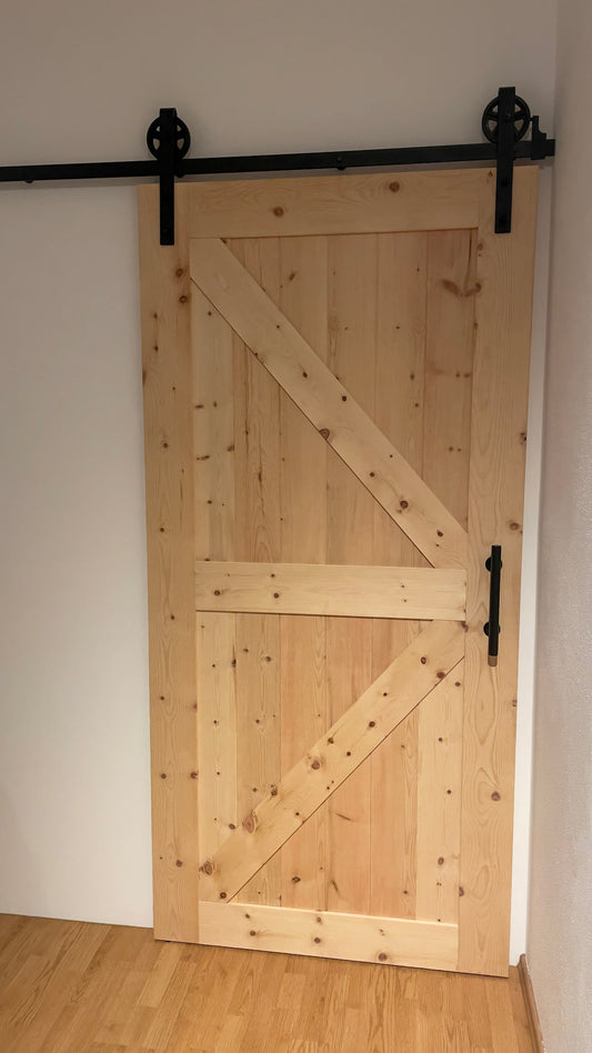 eine Holztür mit einem schwarzen Metallgriff