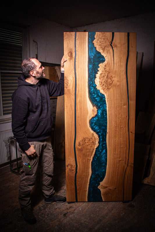 ein Mann, der neben einem großen Holzstück steht