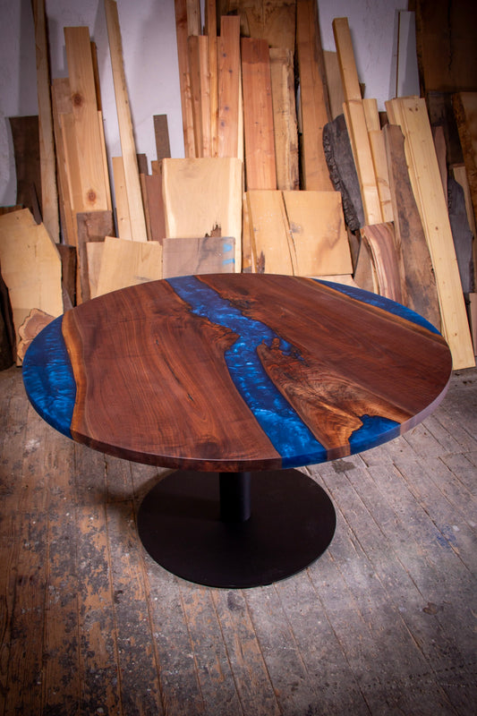 Der runde Esstisch „Ove“ von GussHolz aus heimischem Nussbaum, mit beeindruckenden Epoxidharzdetails, perfekt als Couchtisch, Beistelltisch oder für gesellige Runden. Entdecken Sie exklusive Tische in München und kaufen Sie Unikate wie diesen runden esstisch Massivholz mit baumkante und schwarzem Gestell.