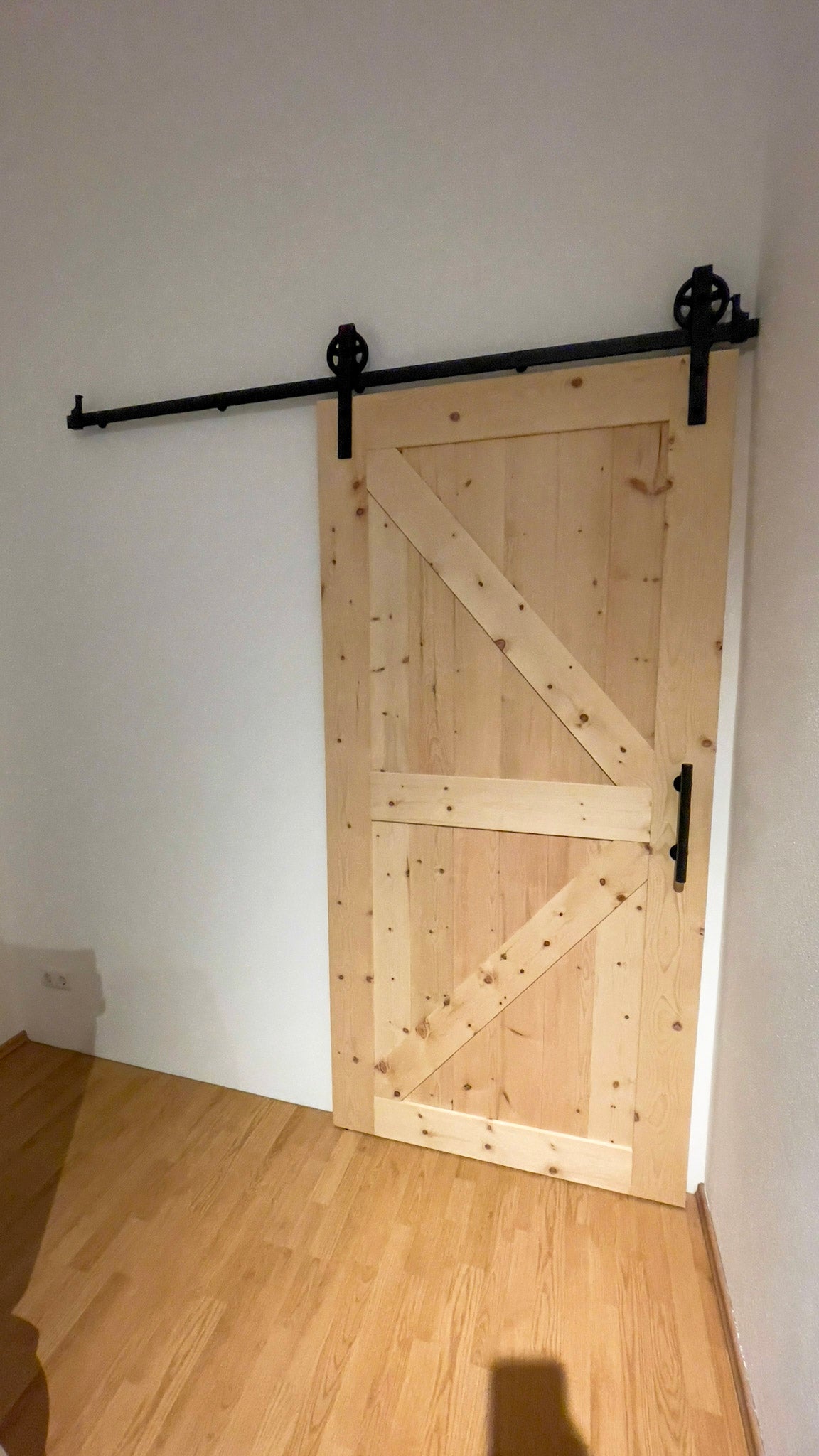 ein Raum mit einem Holzboden und einer Schiebetür