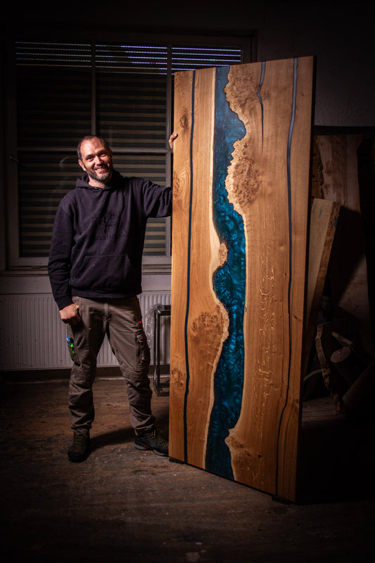 ein Mann, der neben einem großen Holzstück steht