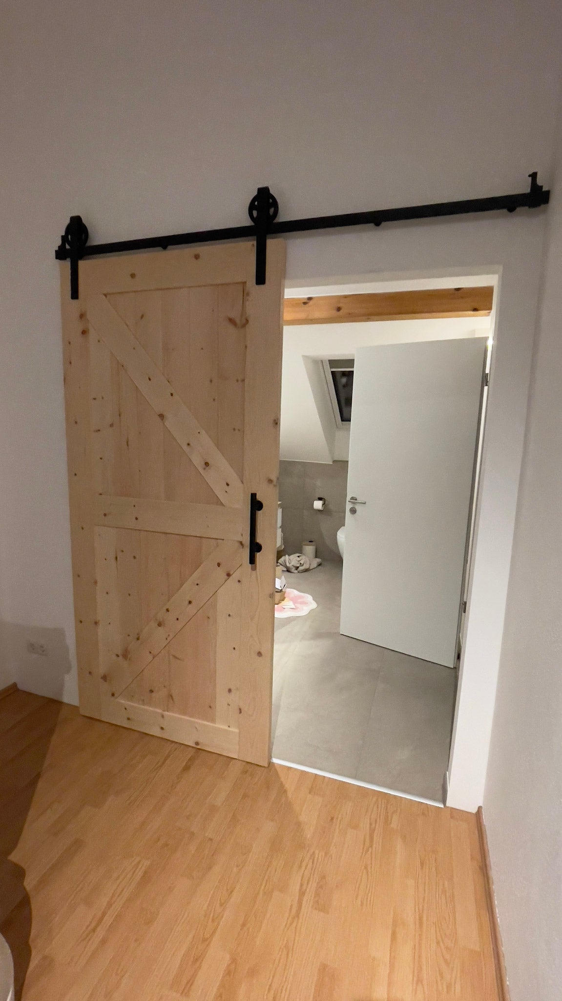 ein Raum mit einem Holzboden und einer Schiebetür