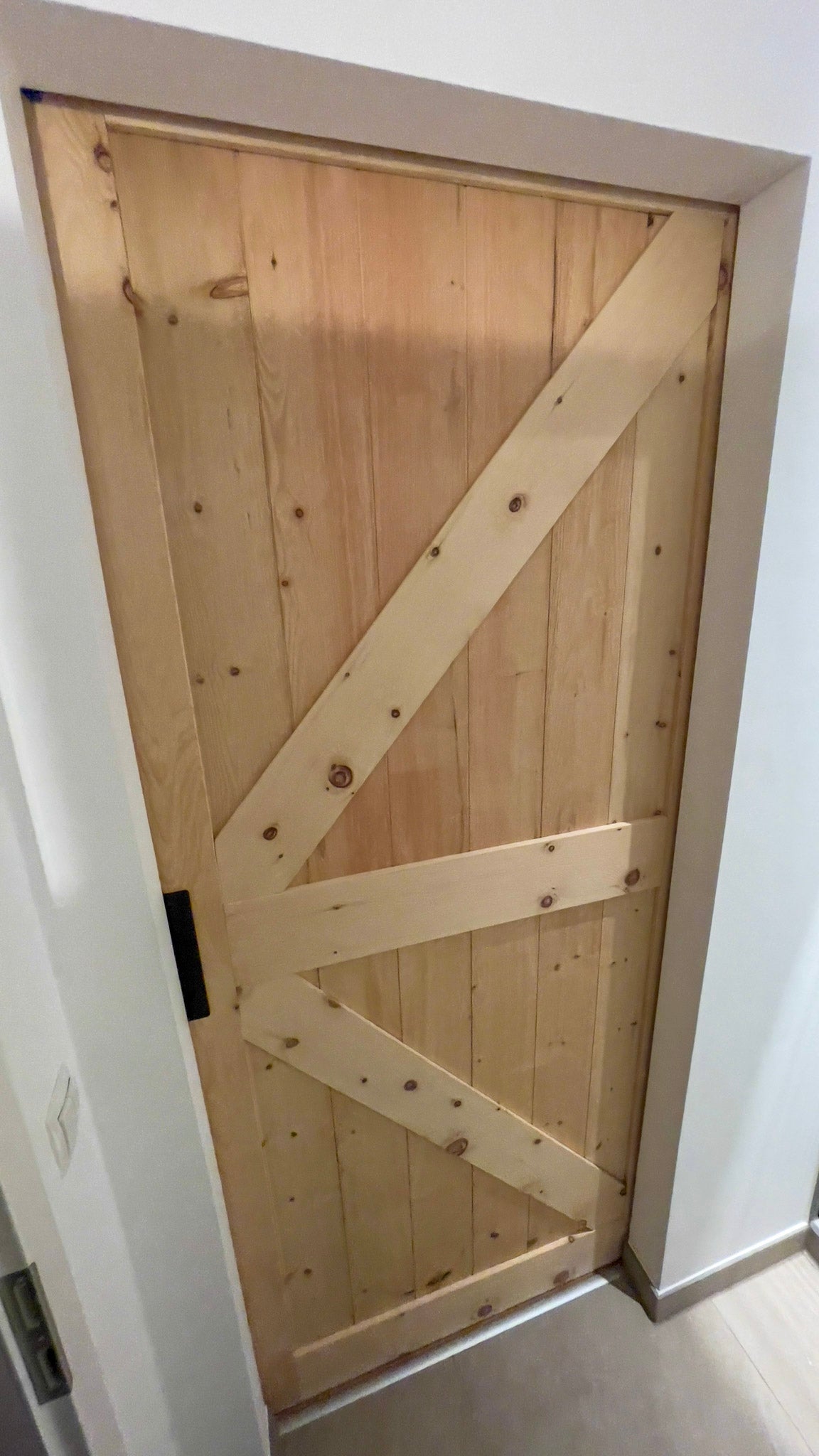 eine Holztür mit einem metallenen Riegel daran