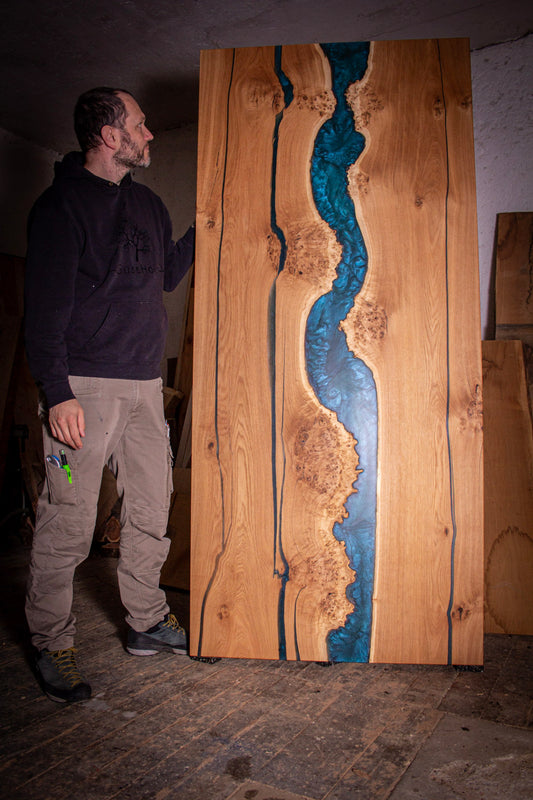 ein Mann steht neben einem großen Stück Holz