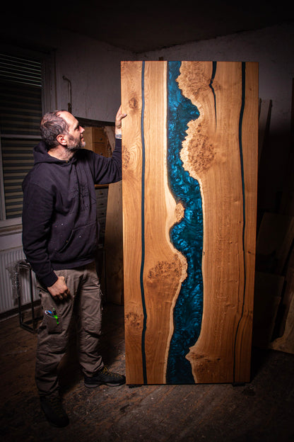 ein Mann, der neben einem großen Holzstück steht