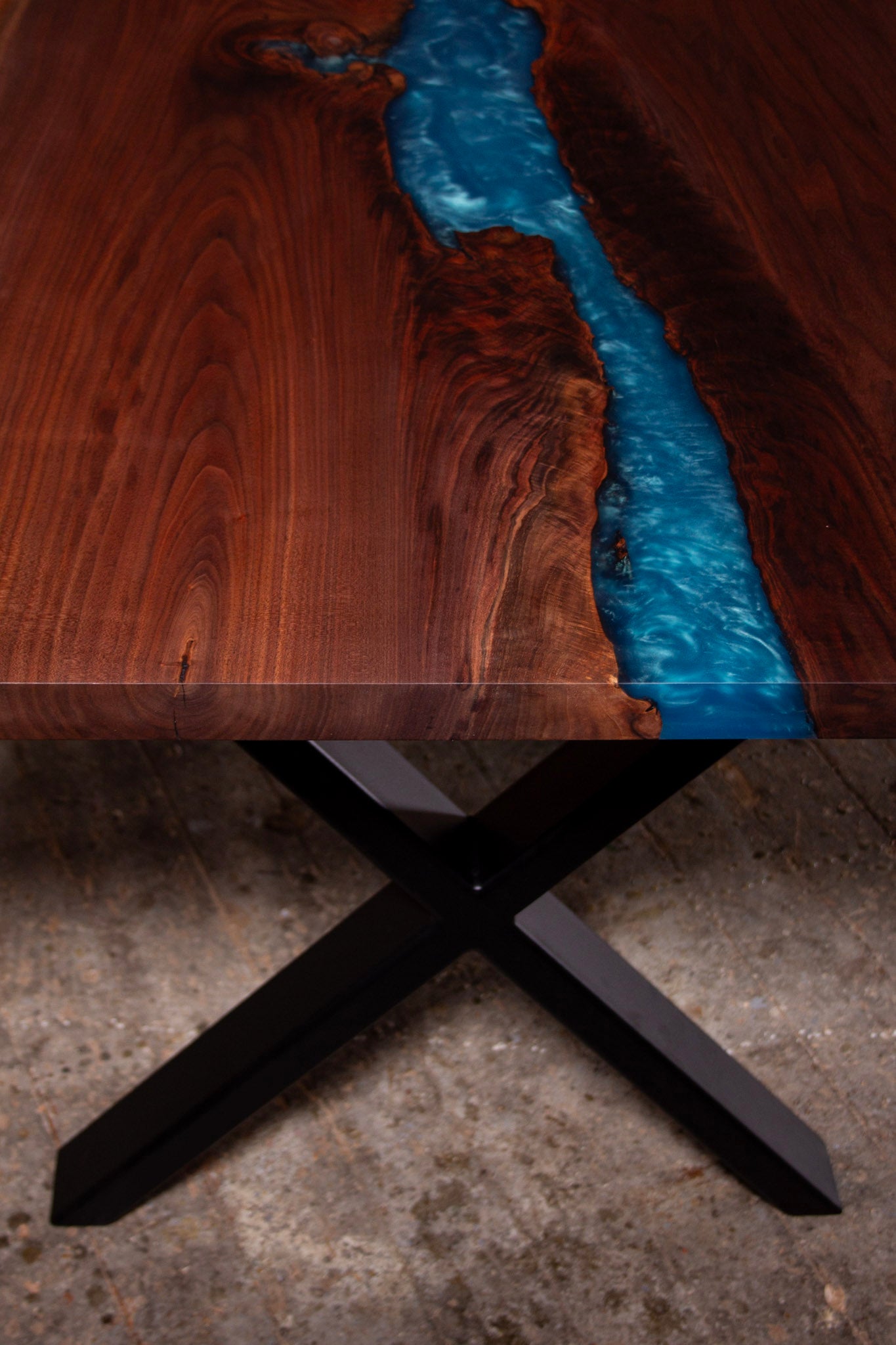 ein Holztisch mit einem blauen Fluss in der Mitte